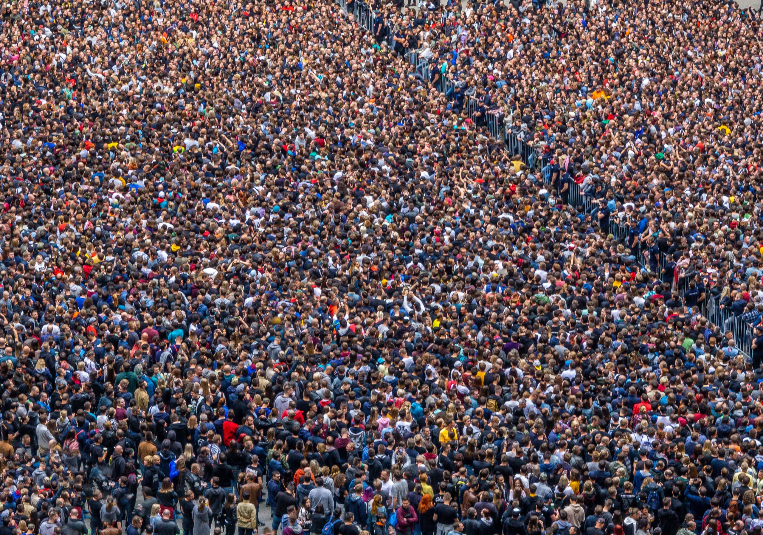 Grosse Menschenmenge, durch Barriere geteilt. (Adobe Stock)